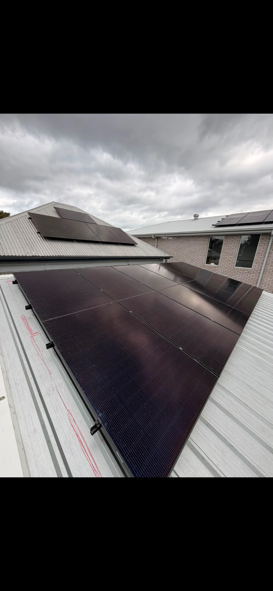 Black solar panels installed on a corrugated metal roof